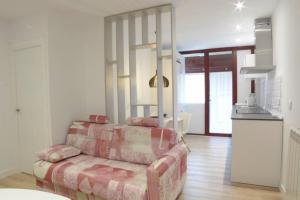 Una sala de estar con un sofá y una cocina. en VUT La Casa de las Flores, en Ávila