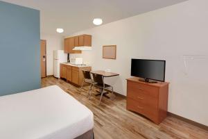 a hotel room with a bed and a flat screen tv at WoodSpring Suites Council Bluffs in Council Bluffs