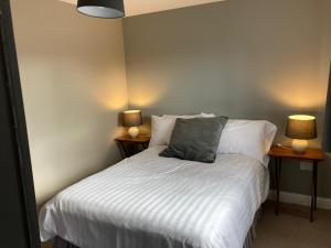 a bedroom with a bed with two lamps on two tables at Sunnyside Holiday Home in Pakefield