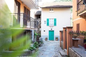 an alley with a green door in a building at Borgo Antico in Luino