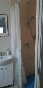 uma casa de banho com um chuveiro e uma cortina de chuveiro branca. em Butas Vytauto 7-4 em Rokiškis