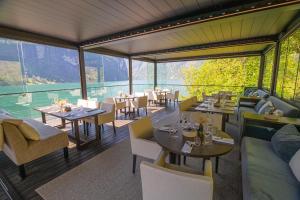 restauracja ze stołami i krzesłami oraz dużym oknem w obiekcie Grande Fjord Hotel w mieście Geiranger