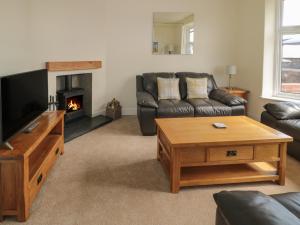 a living room with a couch and a fireplace at Hazonleigh in Seahouses