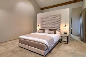 a bedroom with a large bed with a large headboard at DURBUY SUITES in Durbuy