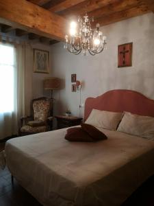 a bedroom with a large bed and a chandelier at Mare Colline Relax in Montignoso