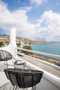 Un balcón con sillas y vistas al océano. en Obsession Mykonos en Agios Stefanos