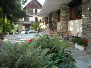 a patio with chairs and plants and a building at Hotel Tripoli La Margherita in Limone Piemonte