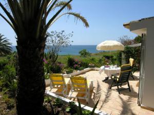 a patio with a table and chairs and a palm tree at VIVENDA JOHANNA in Lagos