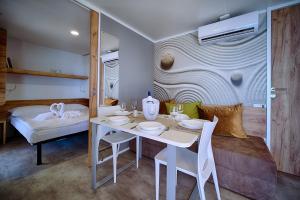 ein Esszimmer mit einem Tisch und einem Bett in der Unterkunft Boutique Camping Bunja in Supetar