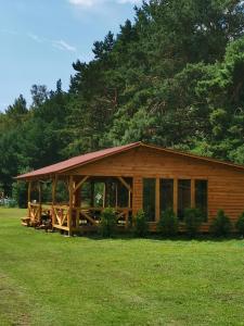 een grote houten hut in een grasveld bij SP camping Spāres Prieduļi in Nīca