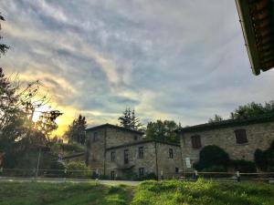 an old stone building under a cloudy sky at La FIABA in Castellina in Chianti