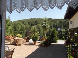 Blick auf eine Terrasse mit Pflanzen und Bäumen in der Unterkunft Pension Waldhof in Trautenstein
