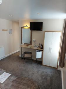 een hotelkamer met een bureau en een spiegel bij PONDEROSA in Blackpool