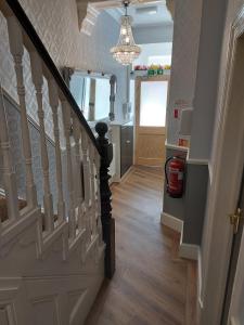 een hal met een trap met een kroonluchter bij PONDEROSA B&B with free onsite parking and breakfast included in Blackpool
