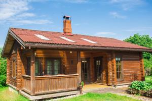 Cabaña de madera con techo rojo en Guest House Baltās Dūjas, en Saulkrasti