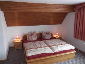 ein Schlafzimmer mit einem Holzbett mit zwei Lampen in der Unterkunft Pension Waldhof in Trautenstein
