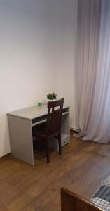 een bureau met een stoel in een kamer met een gordijn bij Schodami do Nieba in Krakau