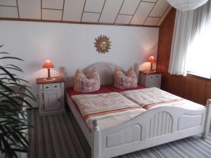 um quarto com uma cama branca com duas mesas de cabeceira em Pension Waldhof em Trautenstein