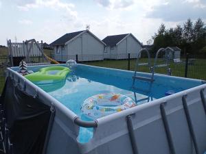 uma piscina num quintal com um parque infantil em Domki Letniskowe Do-Iwi em Ustronie Morskie