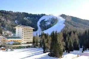 a building in the snow next to a mountain at Alloggio vacanze in montagna per coppia in Folgaria