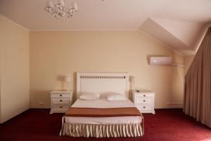 a bedroom with a bed and two dressers and a chandelier at AZIMUT Hotel Nalchik in Nalchik