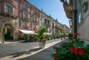 a city street with buildings and plants and flowers at VILLA FARGIONE in Noto