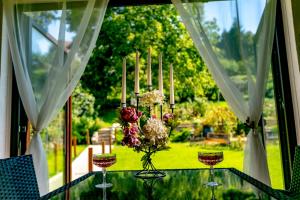 een glazen tafel met een vaas met bloemen erop bij Casa Adalmo in Sighişoara