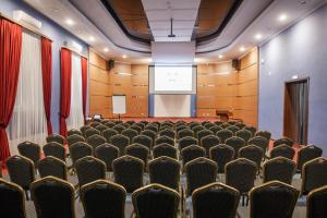 a conference room with chairs and a projection screen at AZIMUT Hotel Nalchik in Nalchik