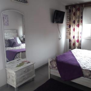 een slaapkamer met 2 bedden en een spiegel bij Bástya apartman in Eger