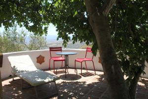 einen Tisch und Stühle auf einer Terrasse mit einem Baum in der Unterkunft El Nispero Dulce in Alcaucín