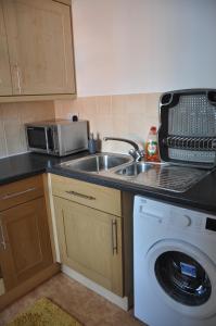 a kitchen with a sink and a washing machine at Modern Home just off Glastonbury High Street in Glastonbury +5 photos