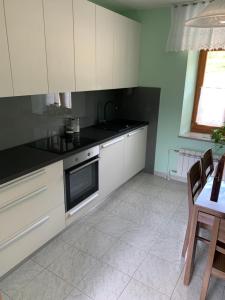 cocina con armarios blancos y fogones en Apartmaji Klabjan - Kaki, en Osp