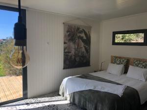 a bedroom with a bed and a large window at Montinho Boutique Studio in Benagil