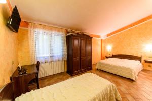 pokój hotelowy z 2 łóżkami i telewizorem w obiekcie Vecchio Mulino w mieście Castel del Giudice