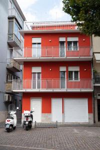 ソットマリーナにあるDIMORA ROSSAの赤い建物の前に二輪車が停まっている