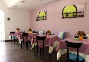 a restaurant with pink tables and chairs in a room at Hotel O'scià in Lampedusa