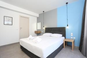 1 dormitorio con 1 cama grande con sábanas y almohadas blancas en Downtown Seaside Suites en Tesalónica