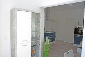 - une cuisine avec des murs blancs et un grand miroir dans l'établissement Ferienwohungen Arnold Boppard, à Boppard