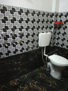 a toilet in a bathroom with black and white tiles at HOTEL AWADH KAILASH in Bahraich