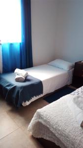 a bedroom with two beds and a window at Rua 5 House in Gafanha da Vagueira