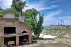 a brick oven with a palm tree and a stone wall at MURIN DELFIN in Umag