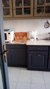 a kitchen with blue cabinets and a counter top at Rua 5 House in Gafanha da Vagueira