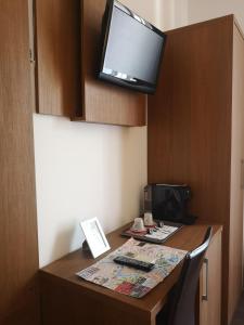 a small desk with a television and a computer on it at Rome Travellers Hotel in Rome