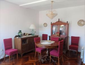 a dining room with a table and pink chairs at Casa Navacastellanos in Casarejos