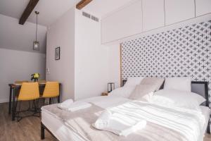 a bedroom with a white bed and a table at Mathias Rex in Szentendre