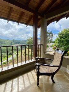 a chair sitting on a porch with a view of the mountains at Atulya Villas Nuwara Eliya in Nuwara Eliya