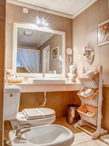 a bathroom with a toilet and a sink and a mirror at Hotel Residencial Alentejana in Coimbra