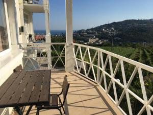 a balcony with a wooden table and chairs on a house at Private house villa Svetlana с сауной и бассейном in Yalta