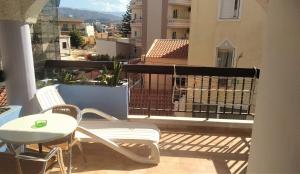balcón con mesa y sillas en Posidonio Hotel, en La Canea
