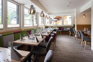 a row of tables in a restaurant with windows at Wander- und Familienhotel Erika in Wagrain